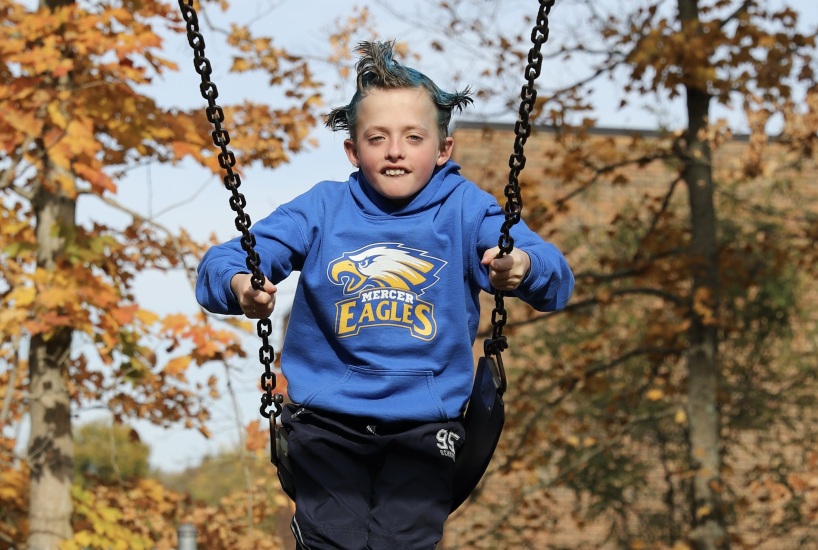 Student on the swing wears a Mercer Eagles sweatshirt